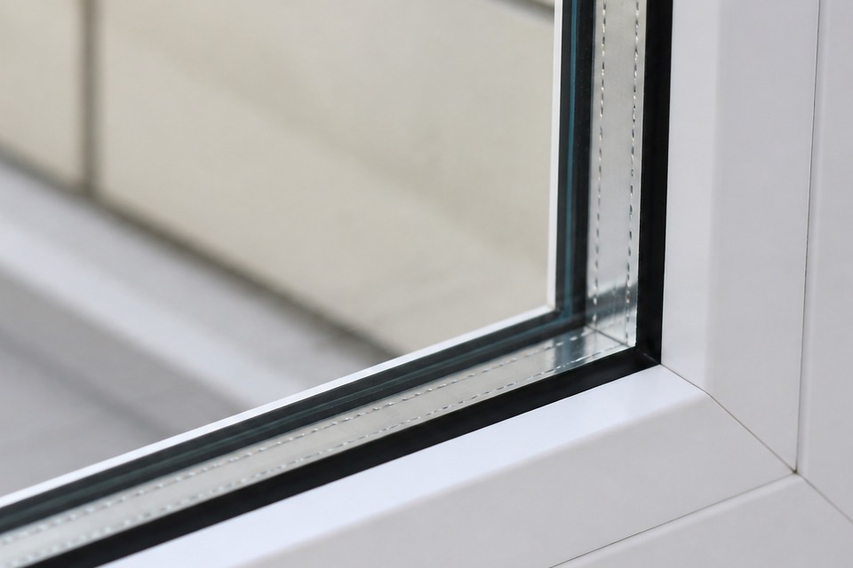 Close view of a double-pane window from outside, the two panes and their spacer bar clear in daylight